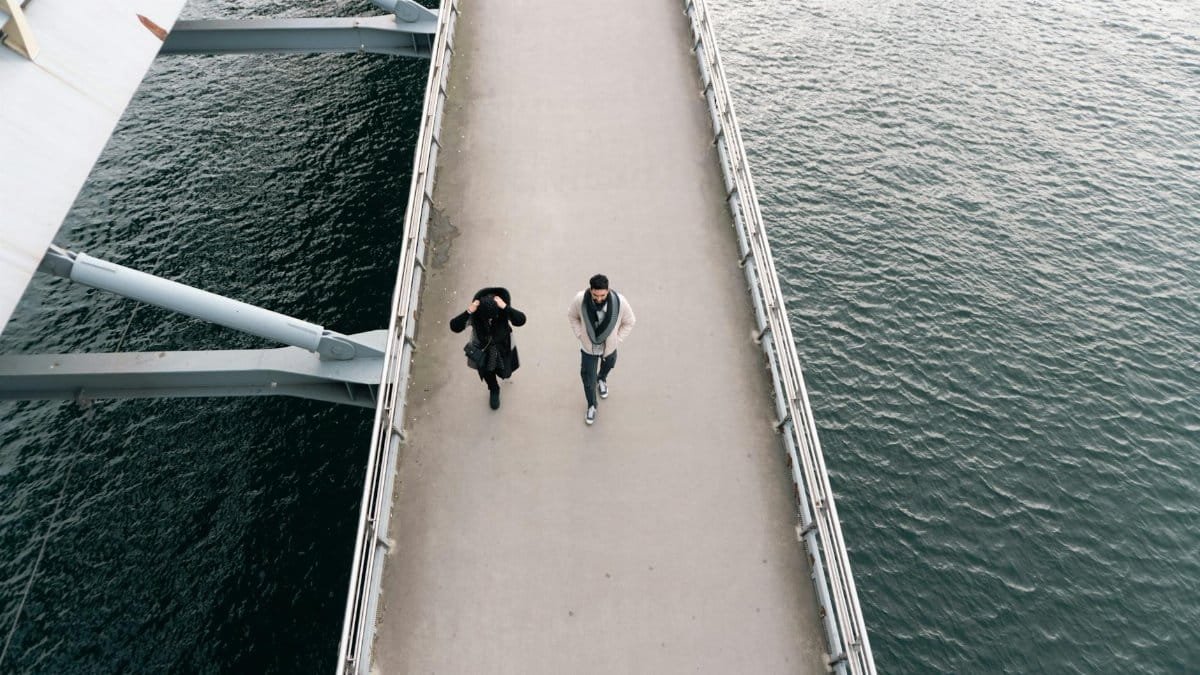 Aerial perspective of two individuals walking along the Bosphorus Bridge in Istanbul.