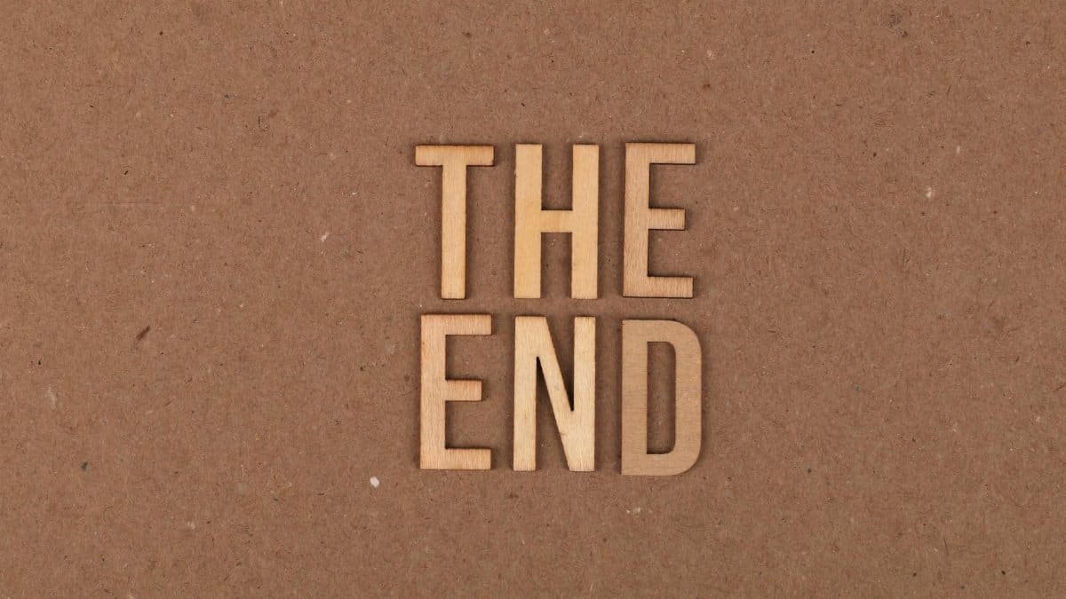 Wooden letters spelling 'The End' on a cardboard background.