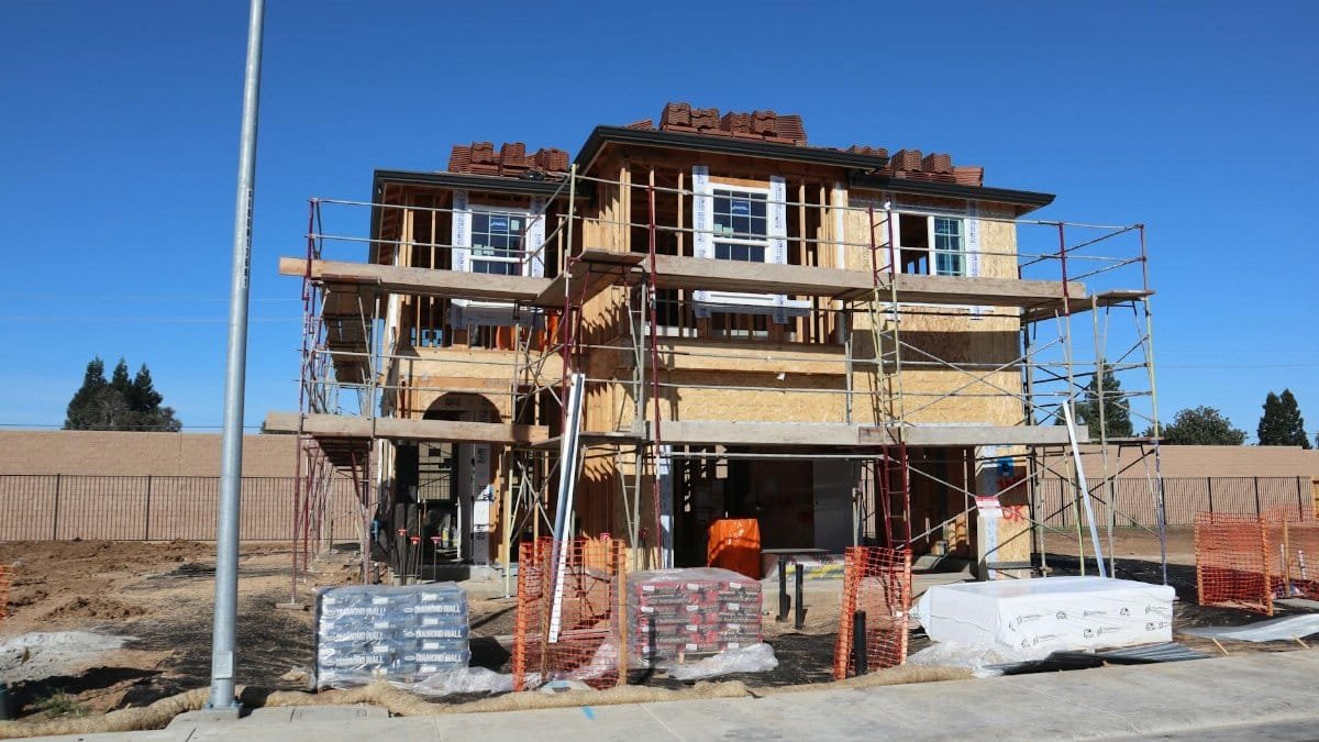 Construction site of a new home development in Elk Grove, California, showcasing scaffolding and materials.