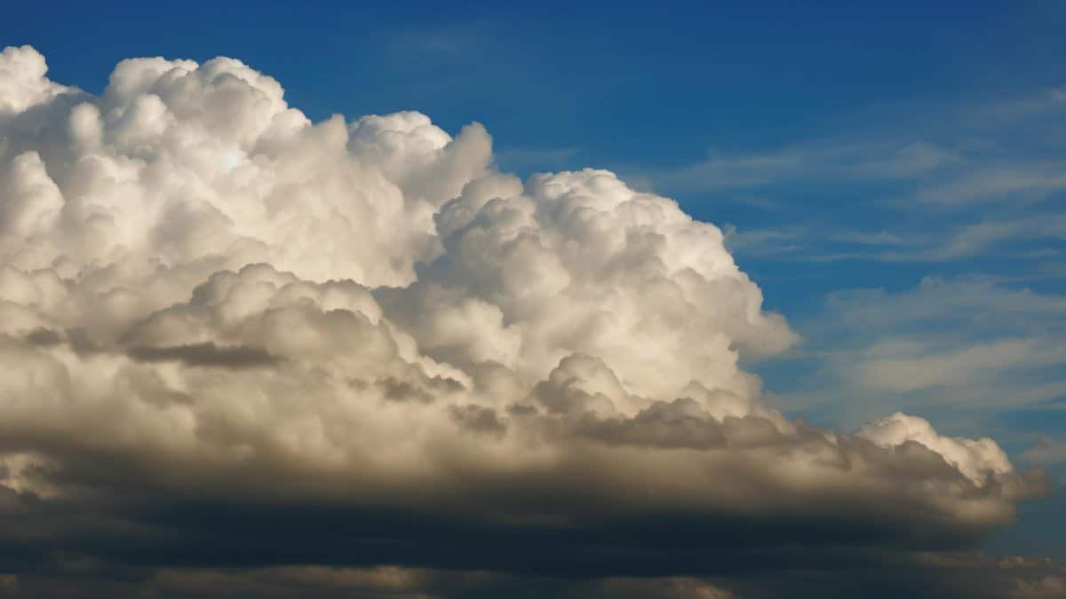 Cumulonimbus clouds forming a dramatic sky against a clear blue backdrop.