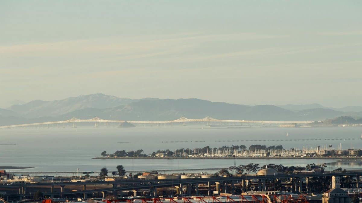Scenic view of San Francisco Bay and bridge with cityscape and mountains.