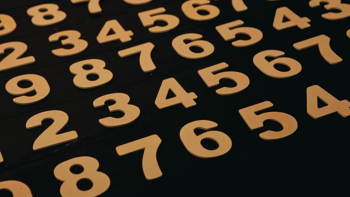 Close-up view of wooden numbers arranged on a black surface, ideal for educational themes.