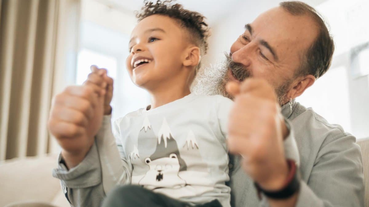Happy moment of a grandfather and grandson enjoying time together indoors. Smiling and connected.