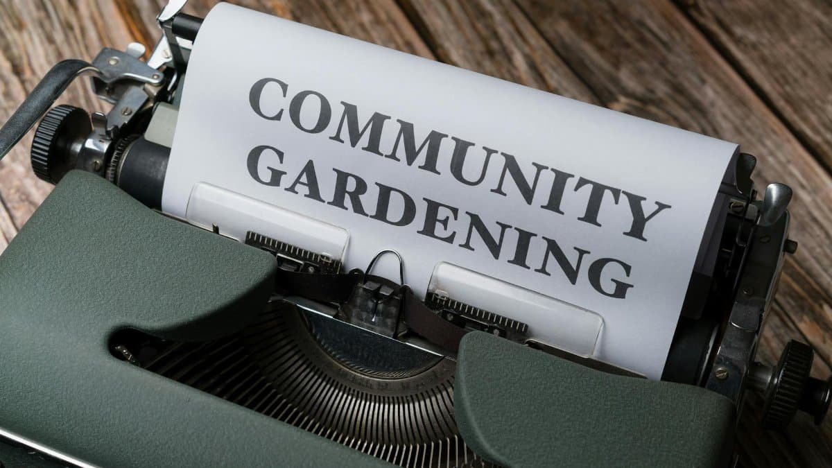 A vintage typewriter with a paper showing the text 'Community Gardening'.