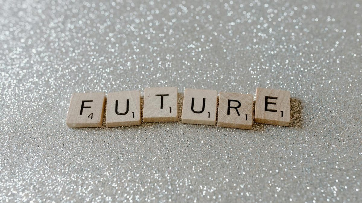 Wooden Scrabble tiles spell 'Future' against a shimmering glitter background.