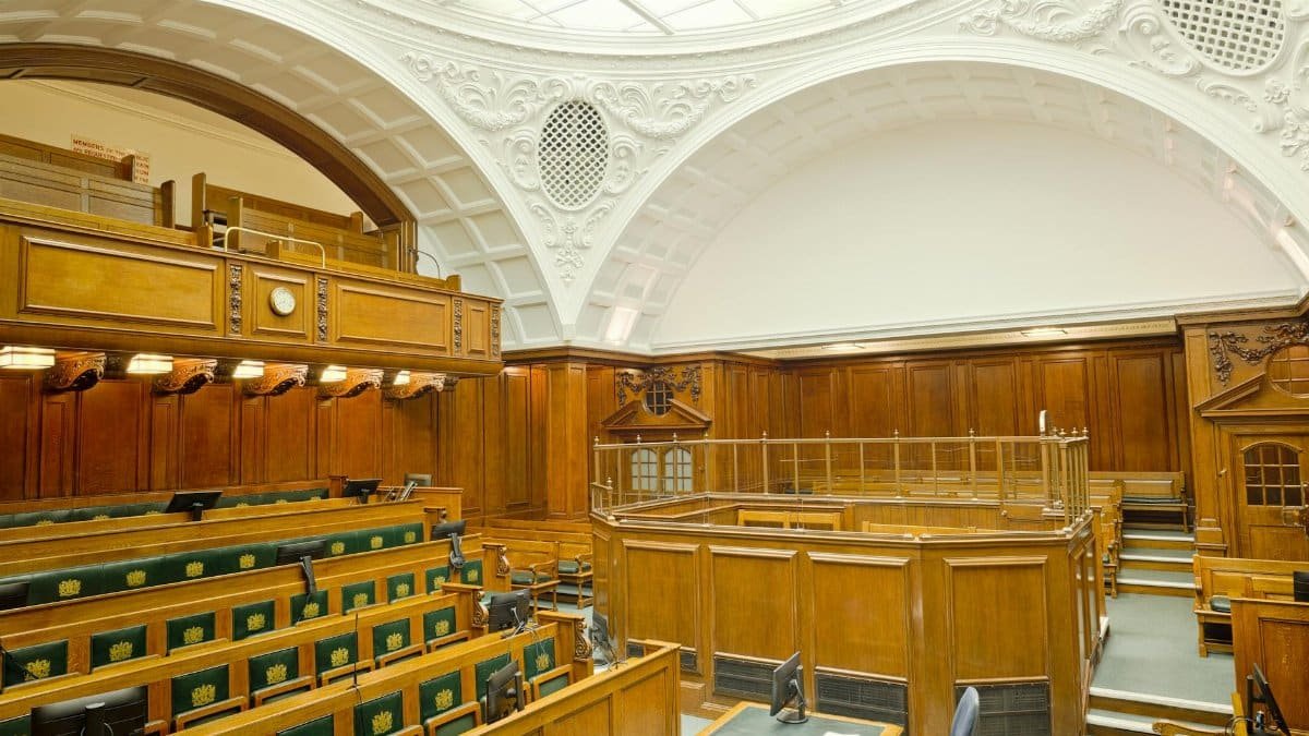 Interior view of a historic courtroom in London with ornate design and wooden furnishing.