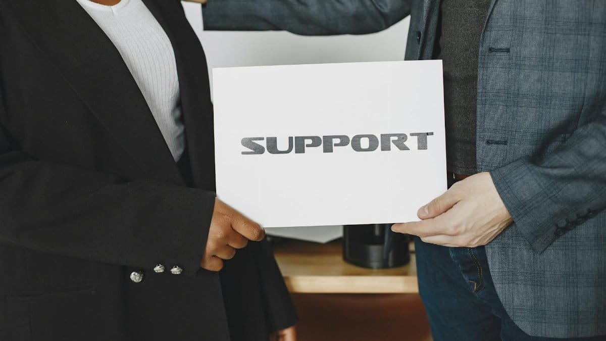 Business diversity and support concept with professionals holding a support sign.