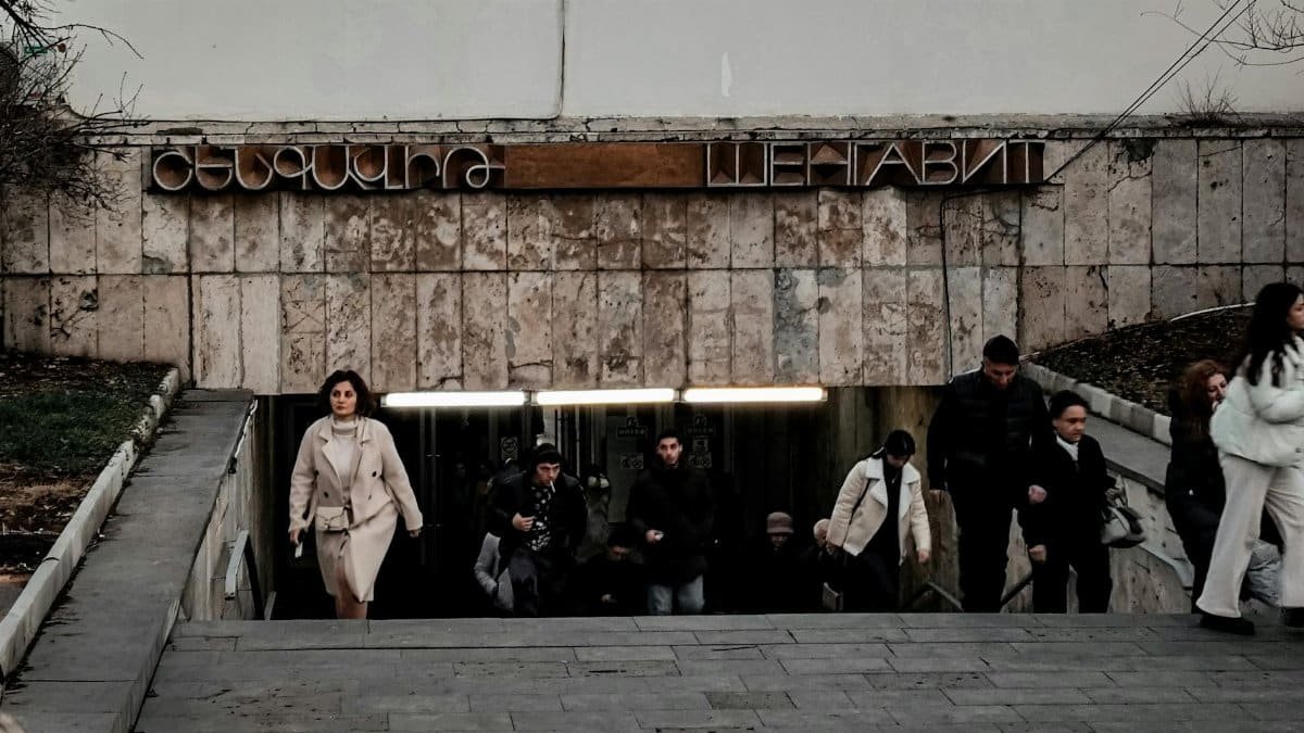 People exiting Shengavit Metro in Yerevan during evening rush hour, showcasing Soviet architectural style.