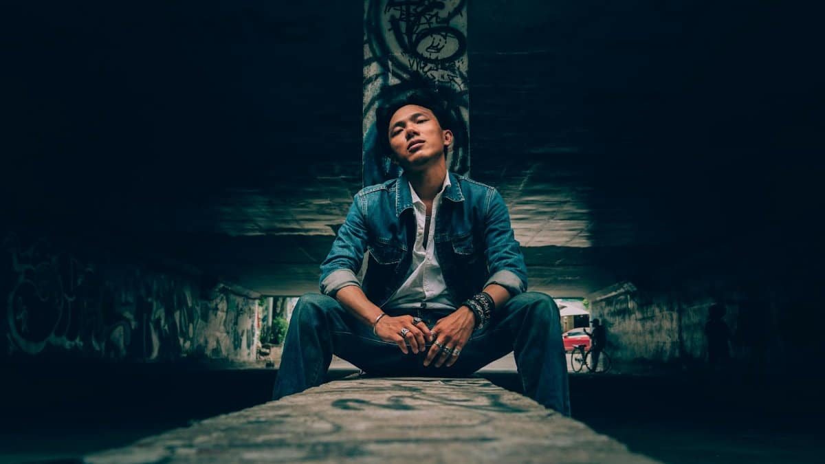 Man in denim sitting in graffiti-filled tunnel in Ho Chi Minh City, Vietnam.