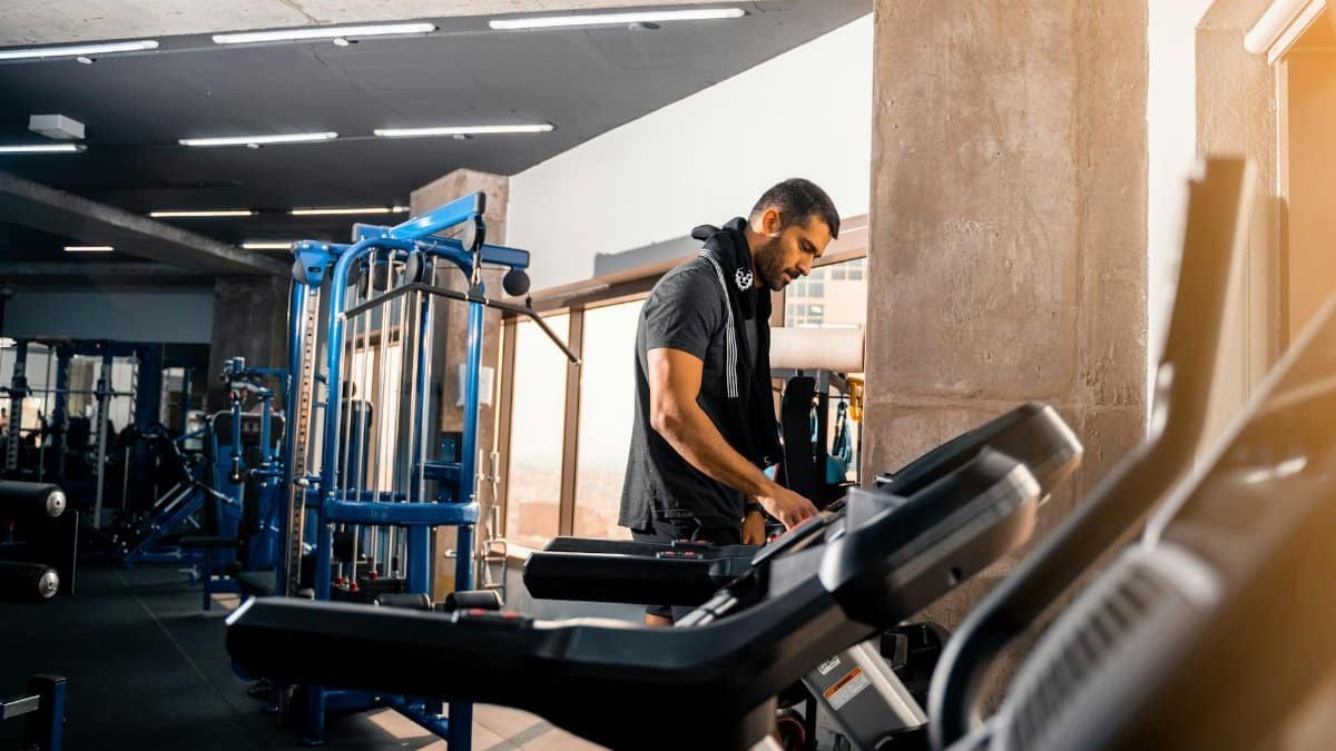 A man with short hair works out on a treadmill in a modern gym in Bahrain.