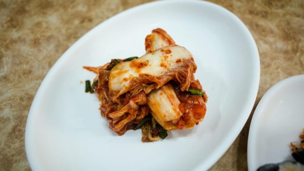 A plate of traditional fermented Korean kimchi presented elegantly on a white dish.