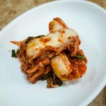 A plate of traditional fermented Korean kimchi presented elegantly on a white dish.