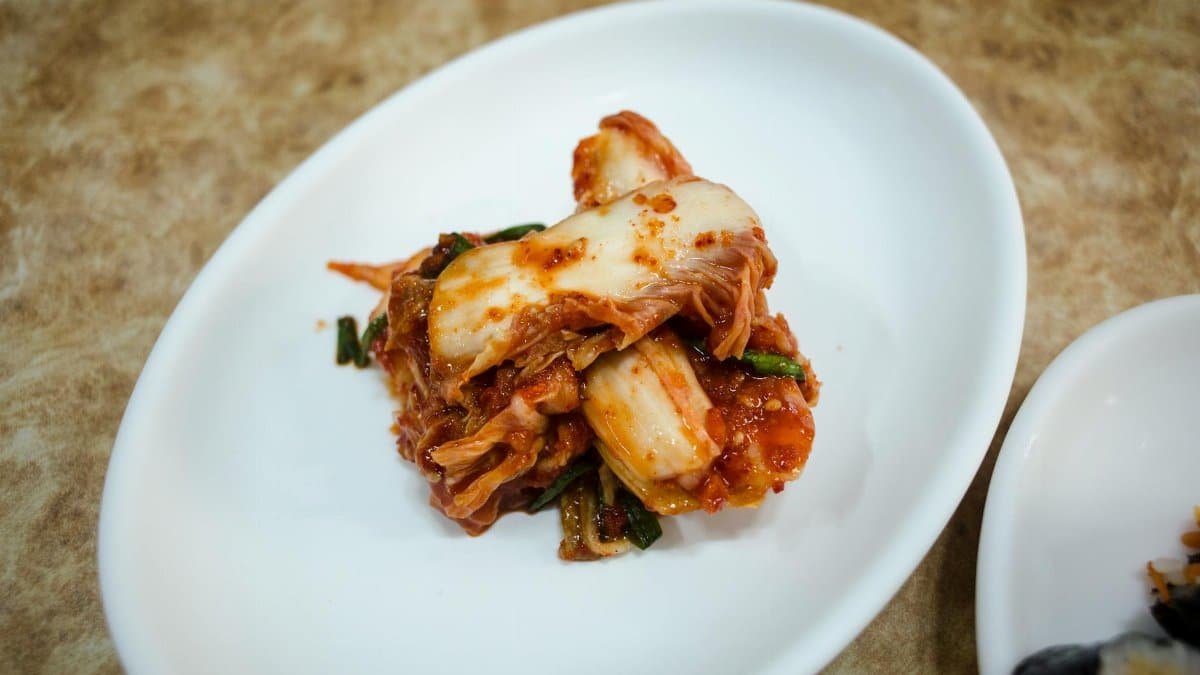 A plate of traditional fermented Korean kimchi presented elegantly on a white dish.