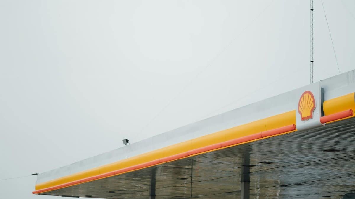 Minimalist view of a Shell gas station canopy against a cloudy sky, emphasizing simplicity and branding.