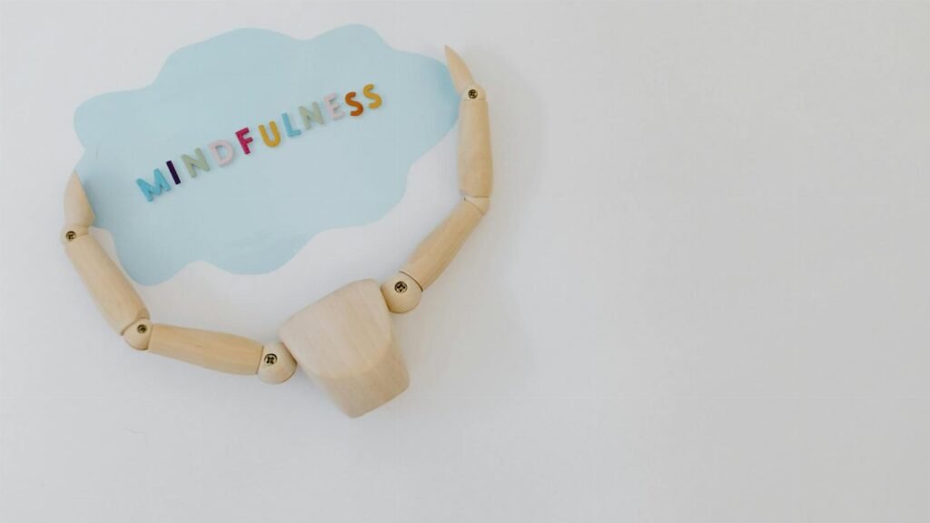 Wooden mannequin holding a mindfulness speech bubble for relaxation and mental health concepts.