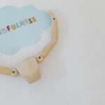 Wooden mannequin holding a mindfulness speech bubble for relaxation and mental health concepts.