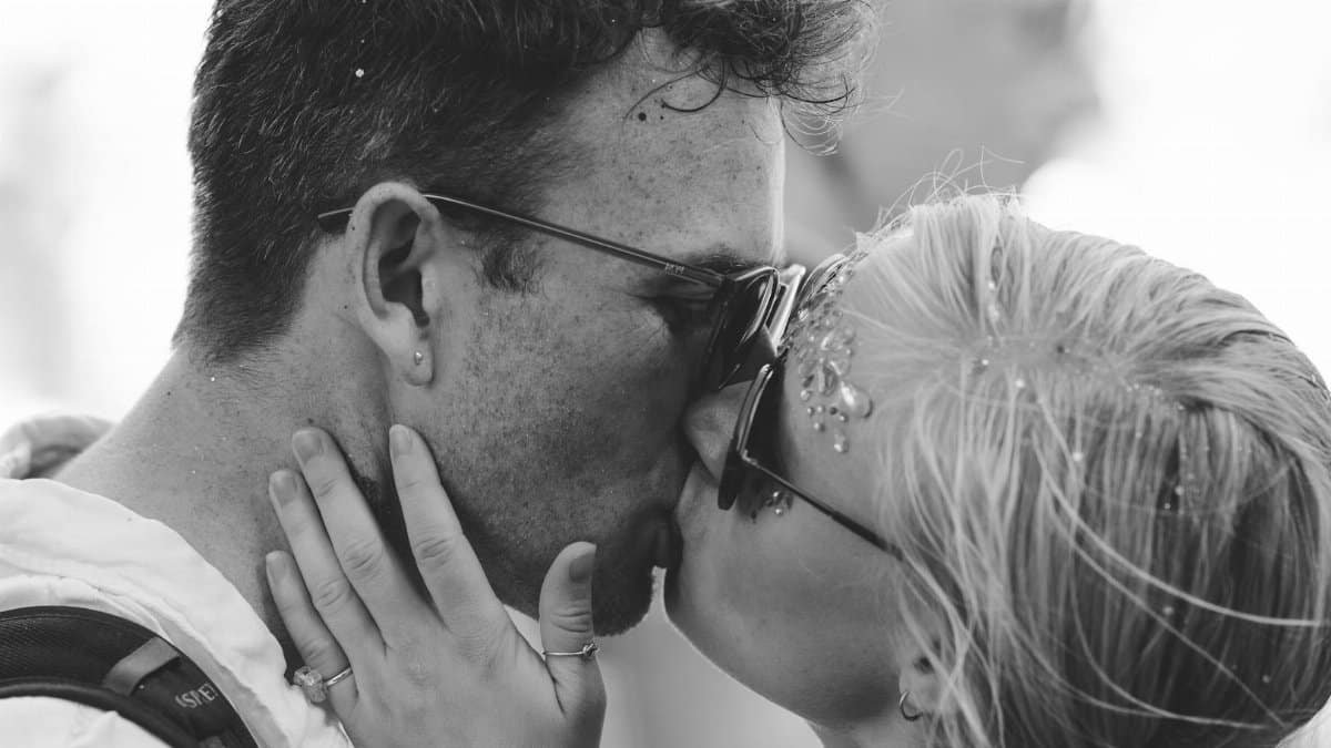 A tender black and white moment capturing a couple kissing with emotion and style.