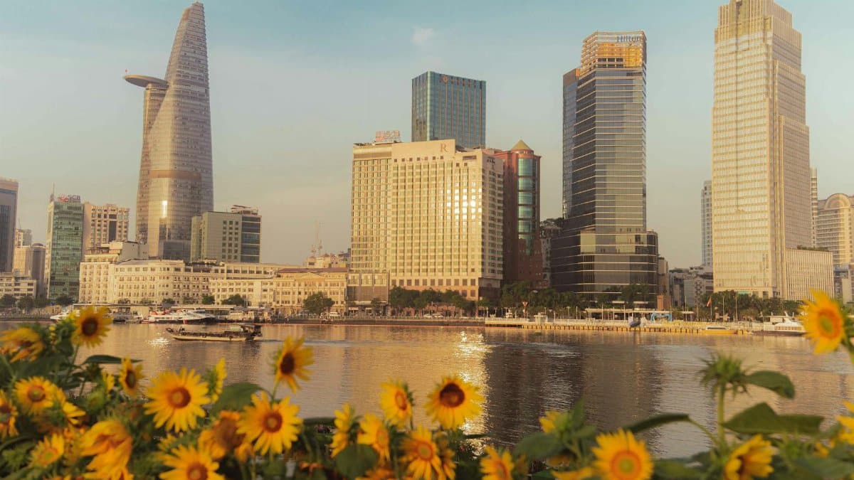 Stunning Ho Chi Minh City skyline view with sunflowers in the foreground.