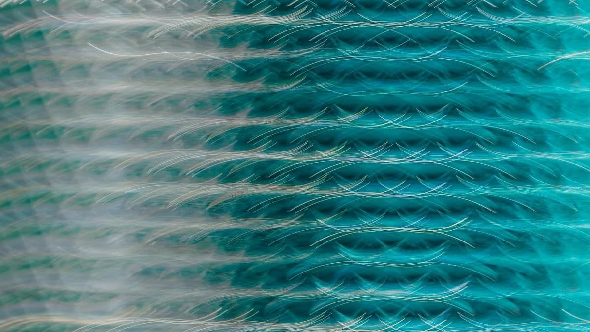 Vibrant abstract artwork featuring a dynamic turquoise steel wave pattern.
