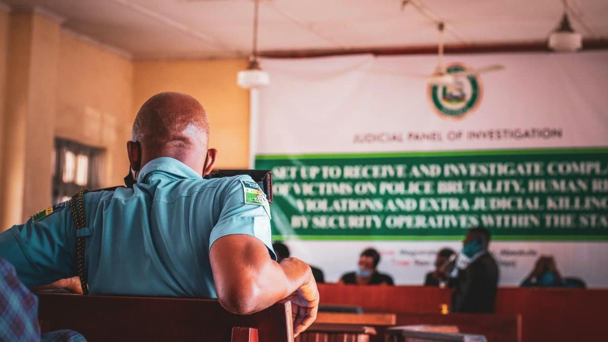 A man in uniform attending a judicial panel meeting indoors.