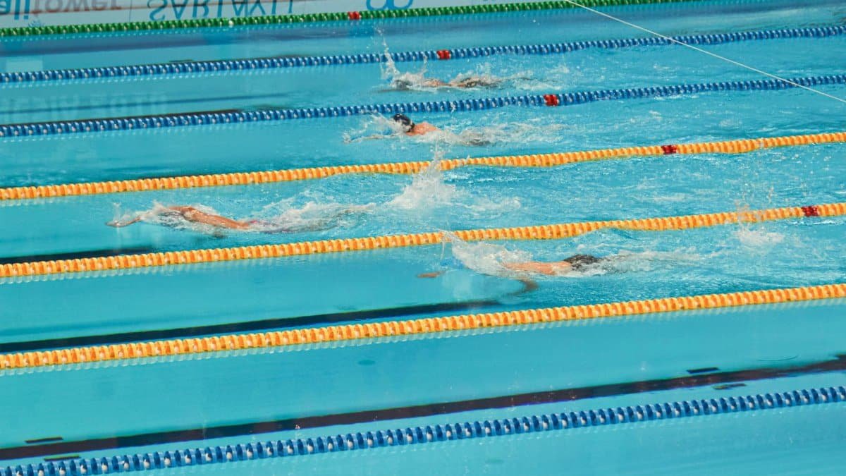 Action-packed swimming competition in Jakarta pool. Swimmers racing in lanes.