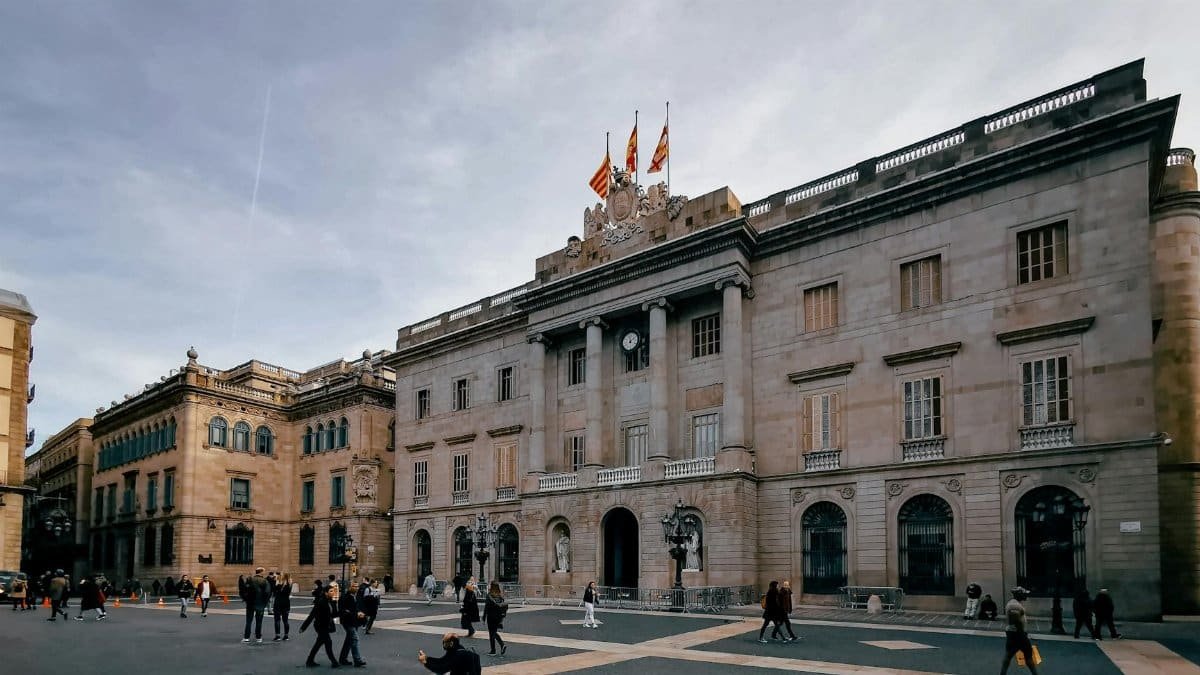 Explore a bustling public square in Spain, surrounded by historic buildings under a cloudy sky.