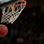 A basketball going through the hoop during a fast-paced game, capturing the excitement of the sport.