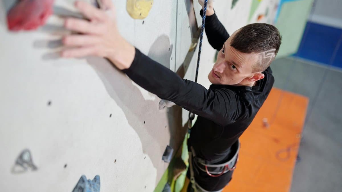 An inspiring image of an amputee man climbing an indoor wall showcasing strength and determination.