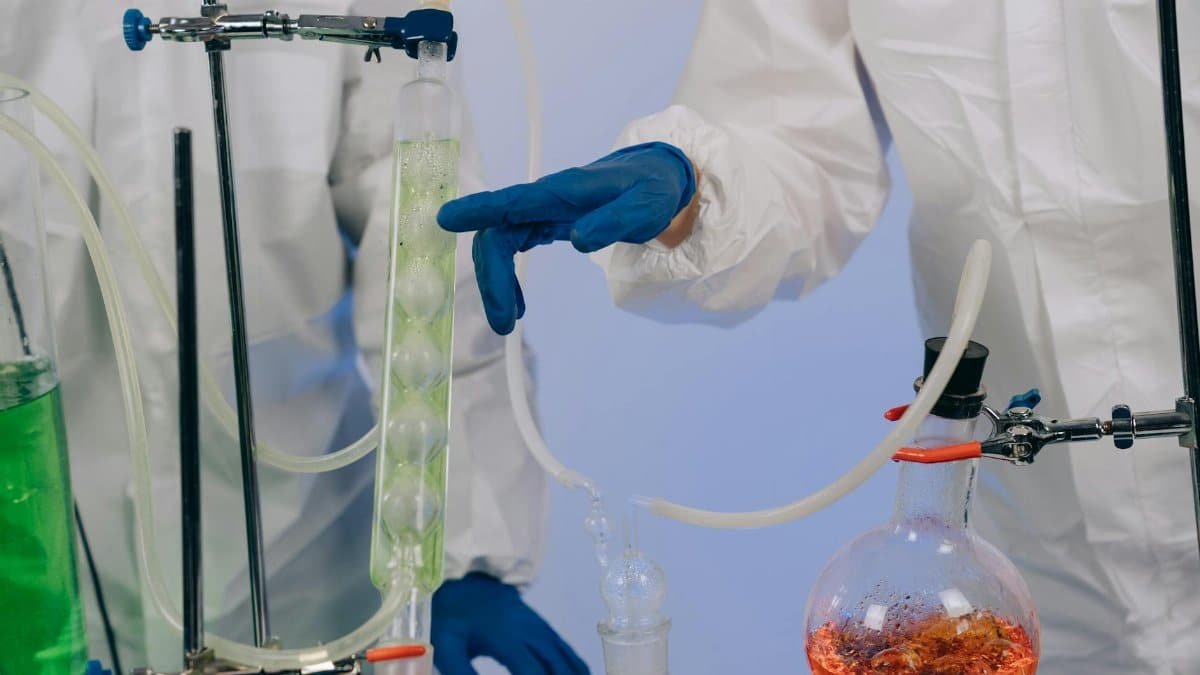Scientists in protective gear perform chemical experiments in a laboratory