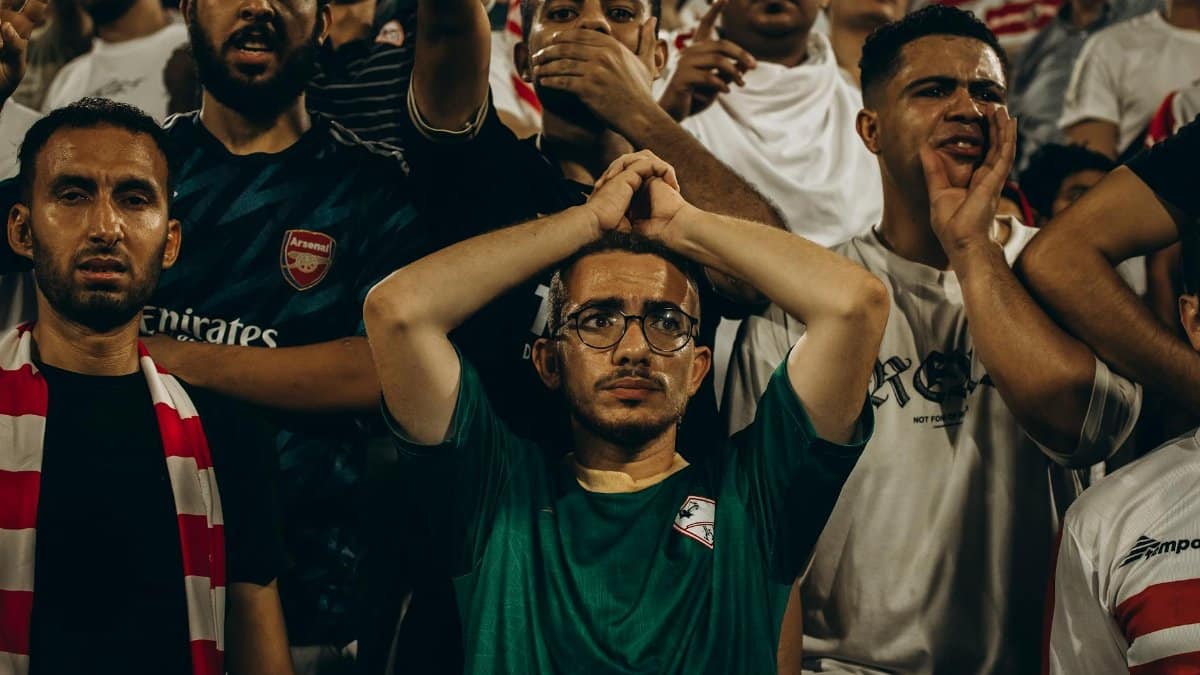 Energetic crowd of football fans showing emotions during a live match.