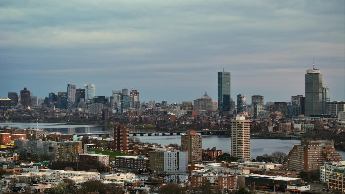 Aerial view of Boston's skyline with the Charles River at dusk, showcasing skyscrapers and urban landscape.