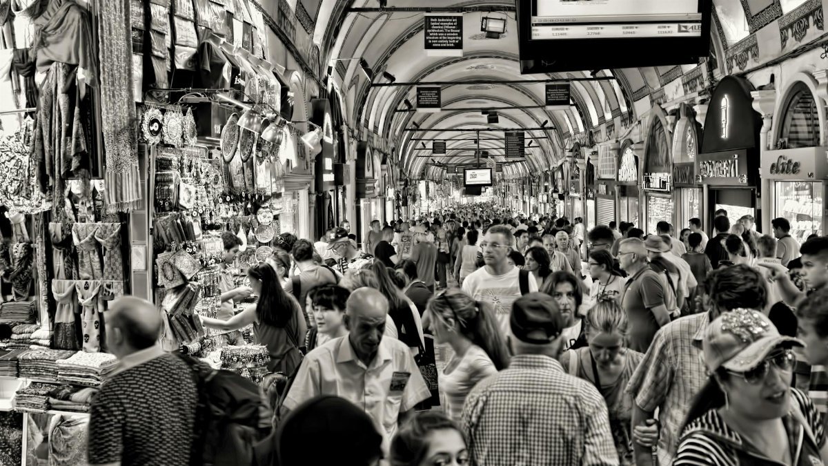 A crowded scene capturing the vibrant commerce of Istanbul's famous Grand Bazaar, showcasing the lively atmosphere and diverse society.