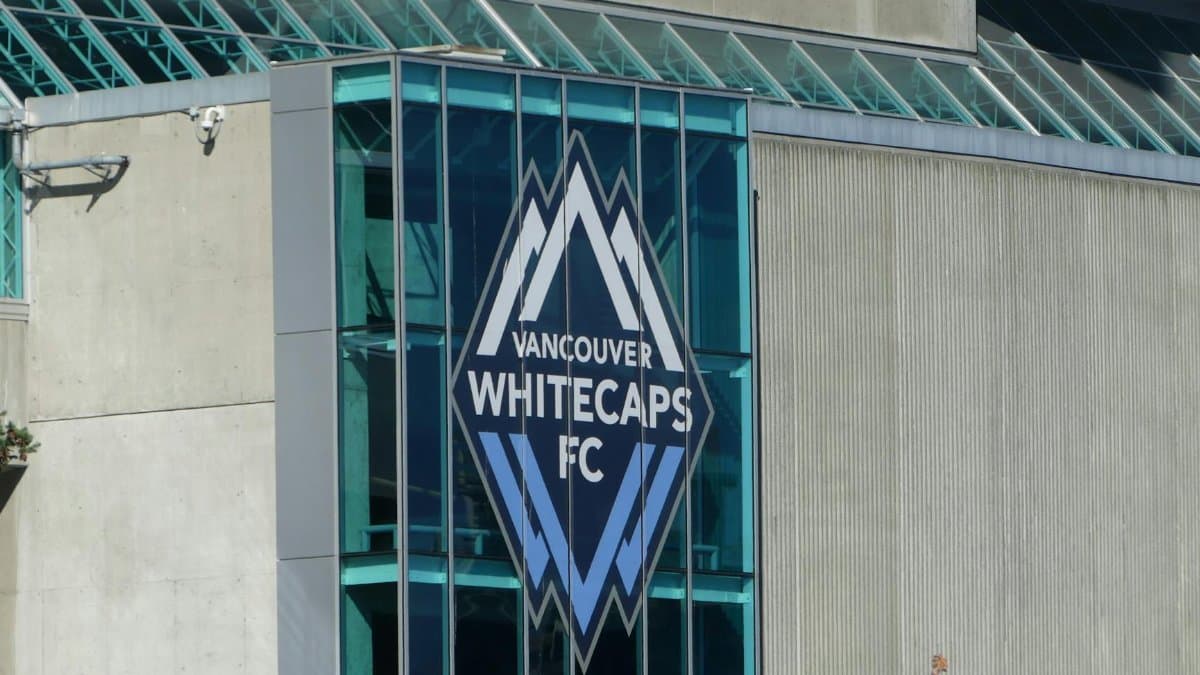 Close-up view of the Vancouver Whitecaps FC logo on the building's glass facade.