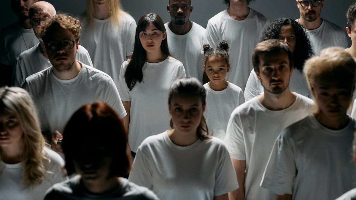 A diverse group of people standing together, emphasizing individuality and unity in a minimalist setting.