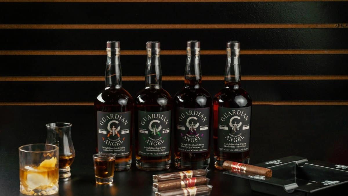 A stylish display of Guardian Angel whiskey bottles with cigars in a New Orleans bourbon bar setting.