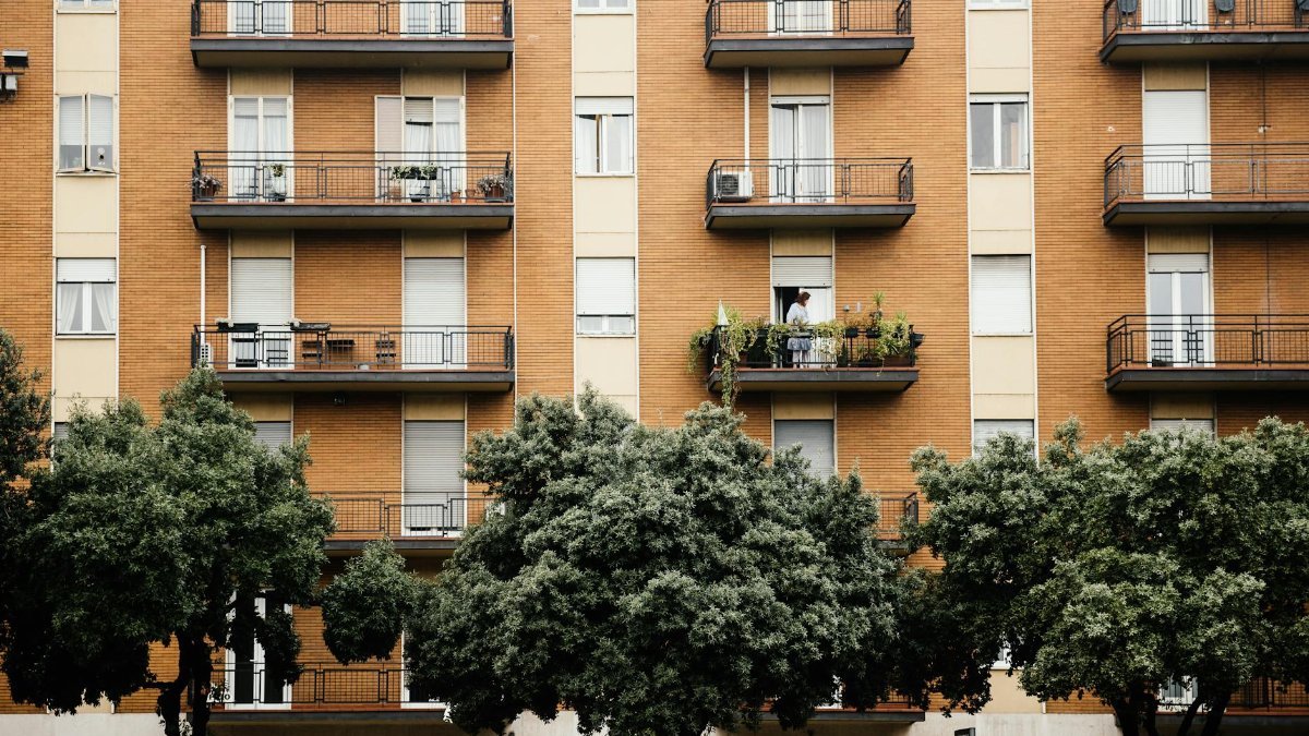 Multi-storey apartment building with balconies and lush greenery for an urban lifestyle.