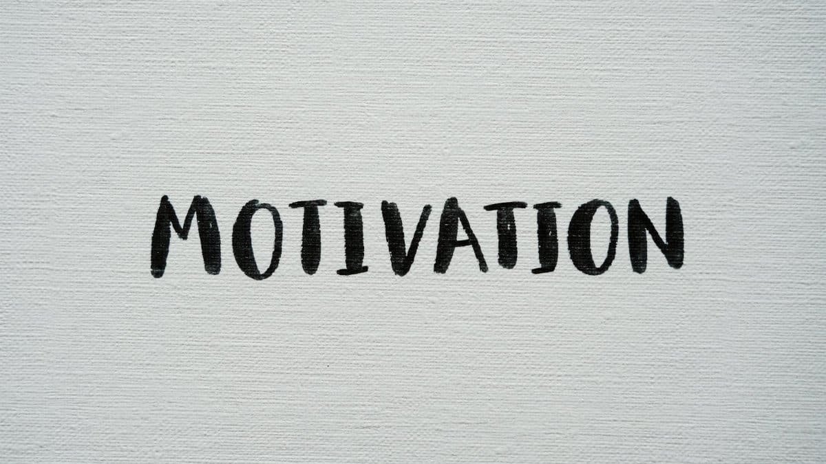 Inspirational word 'Motivation' in black on a white textured canvas background.