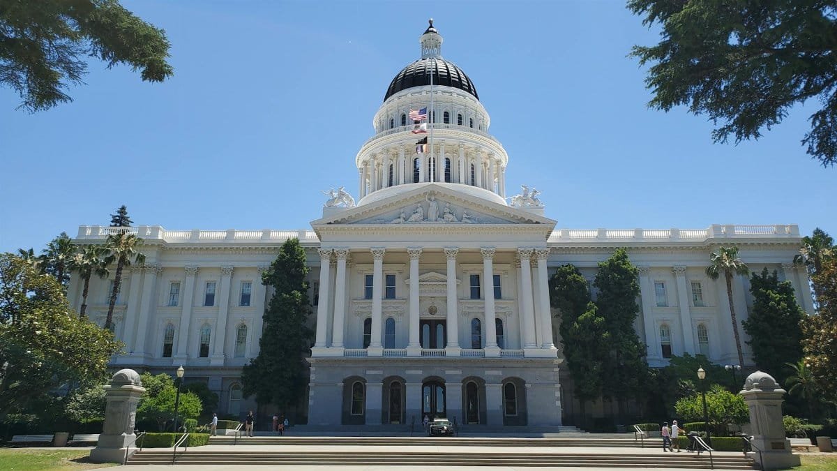 Front view of Sacramento's California State Capitol with clear blue sky.