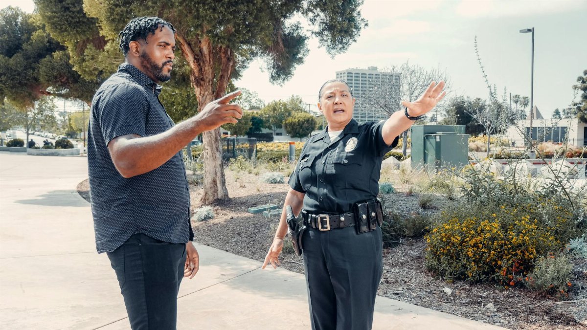 Police officer speaking with a man outdoors, showcasing community engagement.
