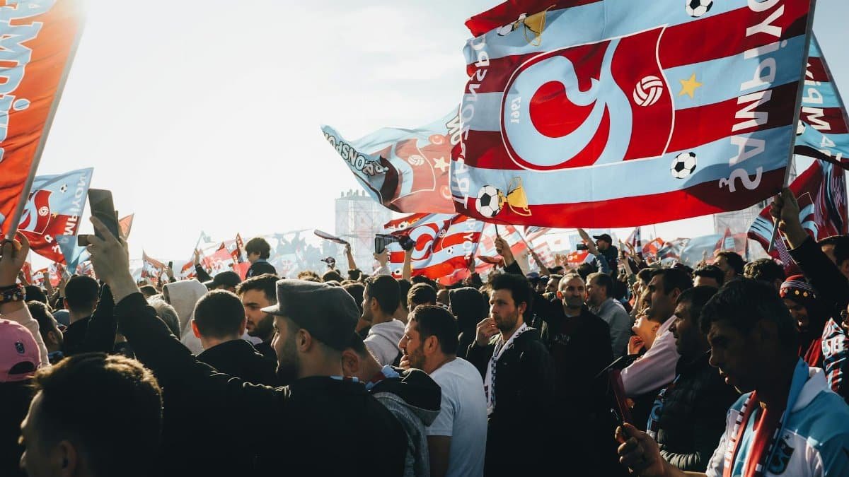 Energetic gathering with colorful flags at a lively outdoor event on a sunny day.