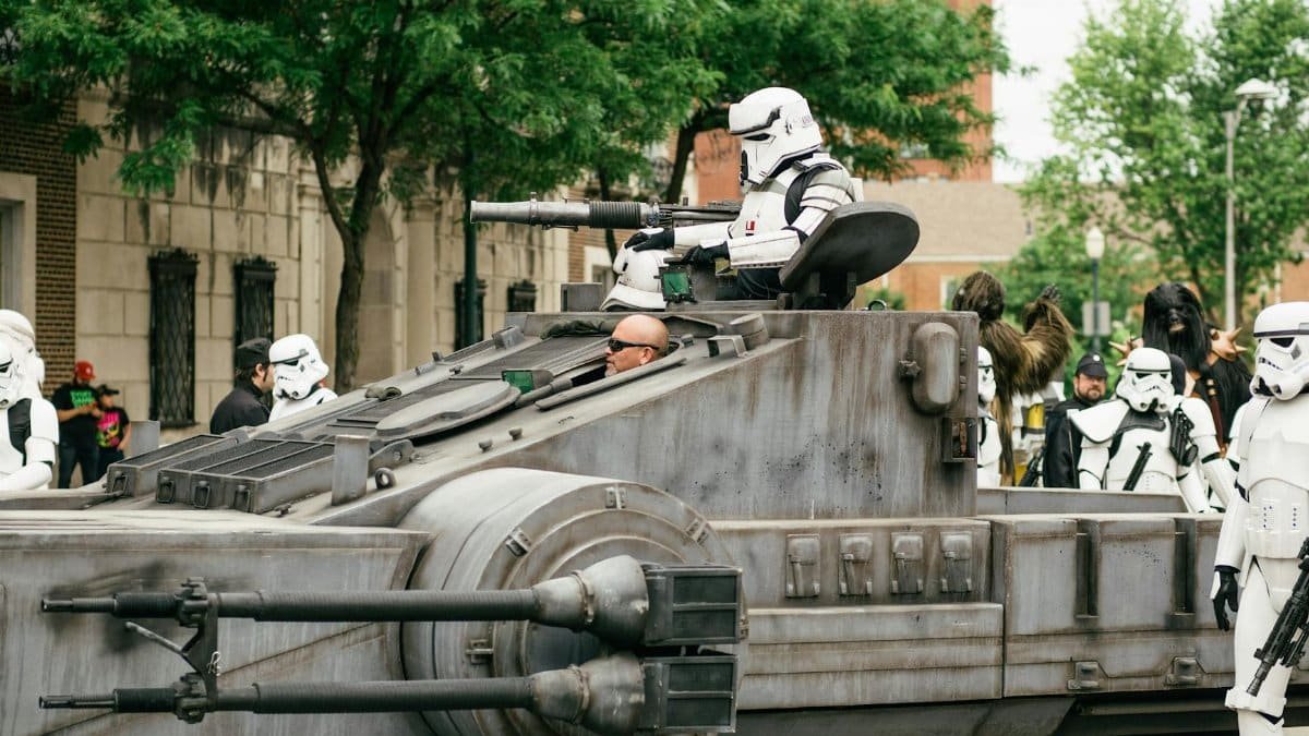 Stormtroopers participating in a cosplay parade featuring a tank-like vehicle in Joliet, IL.