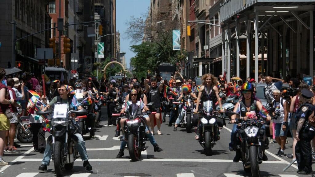 Colorful and lively scene of the Pride Parade in New York City featuring motorcyclists and a diverse crowd.