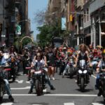 Colorful and lively scene of the Pride Parade in New York City featuring motorcyclists and a diverse crowd.