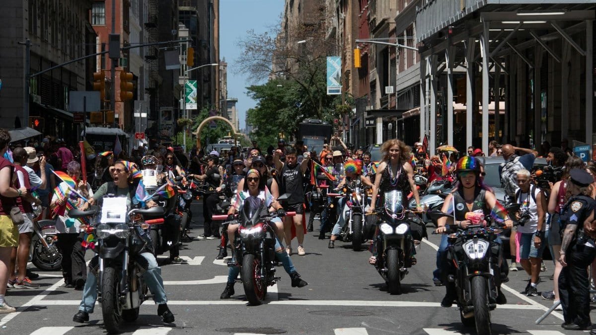 Colorful and lively scene of the Pride Parade in New York City featuring motorcyclists and a diverse crowd.