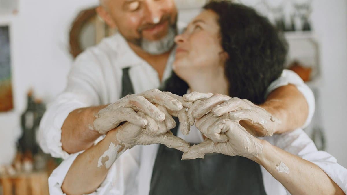 Couple sharing a loving embrace while creating pottery together, symbolizing love and artistry.