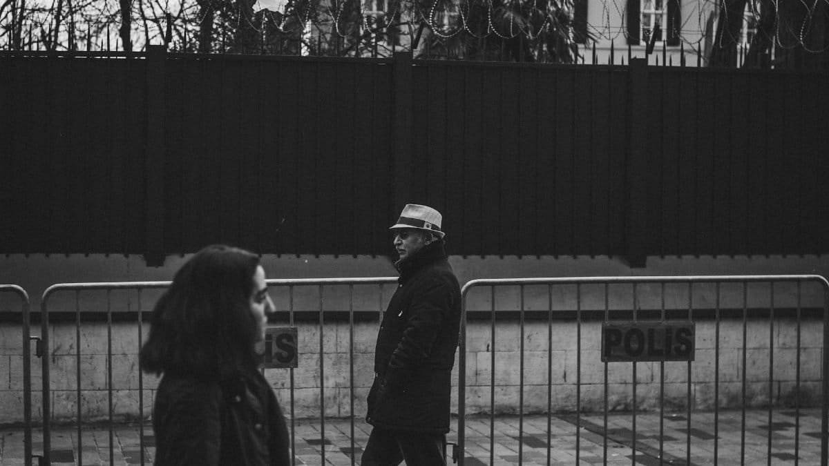 Street photography capturing everyday life near barbed wire fences in Istanbul.