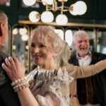Joyful elderly couples dancing indoors, celebrating togetherness and romance.