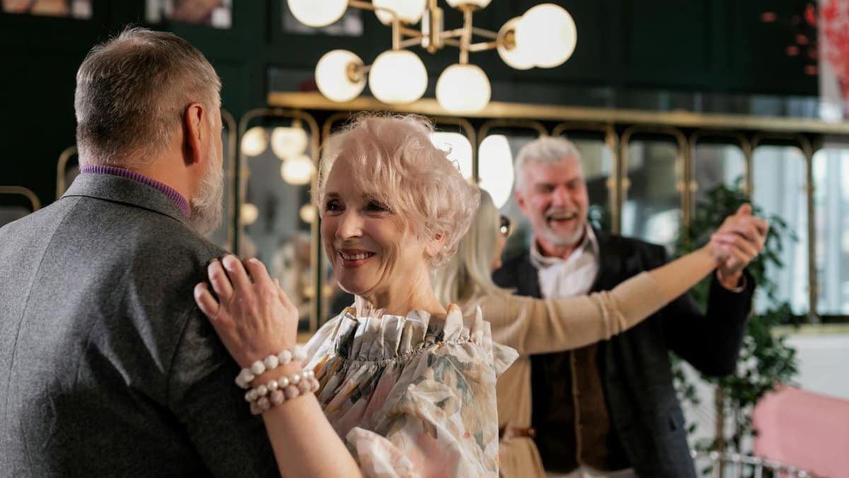 Joyful elderly couples dancing indoors, celebrating togetherness and romance.