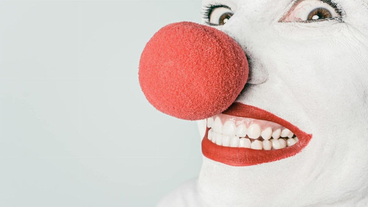 Bright close-up of a clown's face with red nose and makeup, showcasing humor and joy.