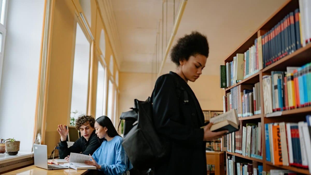 Teenage students engage in reading and studying in a cozy library environment.